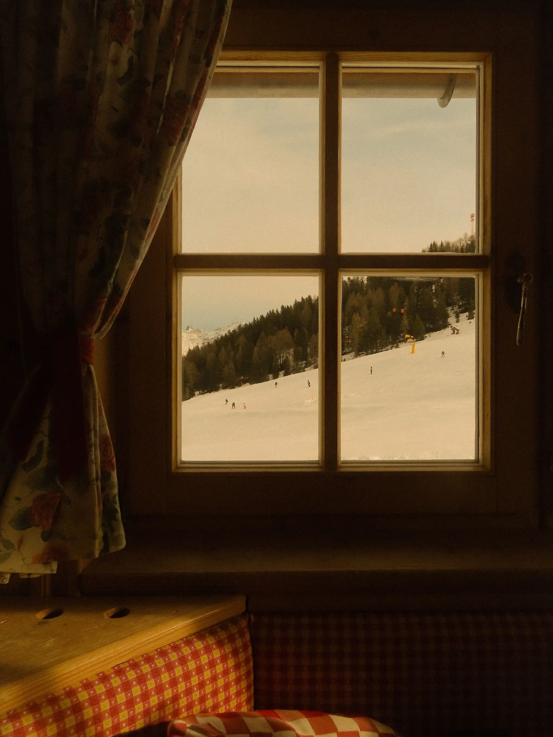 Blick aus dem Zimmerfenster auf verschneite Berge